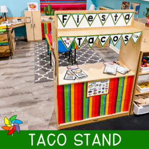 Preschool taco dramatic play center with a "Taco Stand" title and colorful pennant banner.