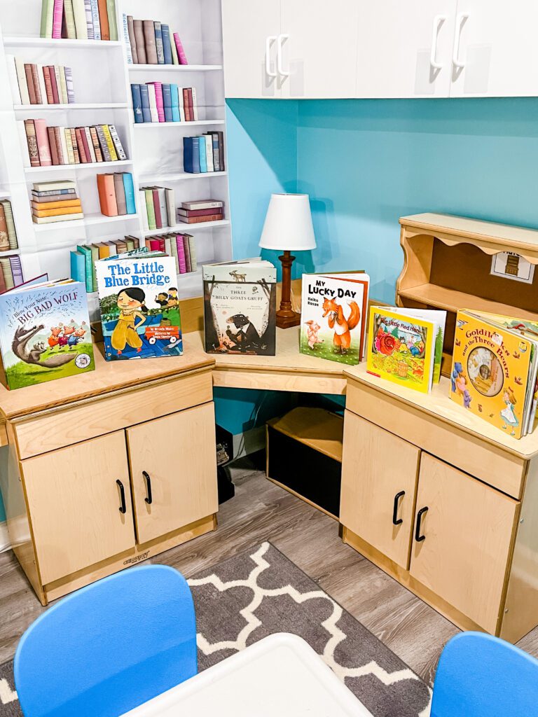books lining shelves in a preschool library dramatic play center