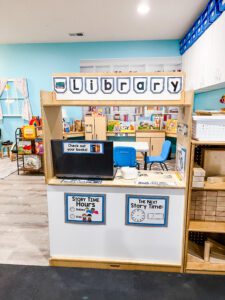 Preschool library dramatic play center - check out counter with signage