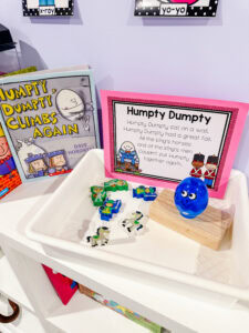 Humpty Dumpty retelling tray with rhyme card, character pieces, a wooden wall, and the book Humpty Dumpty Climbs Again.