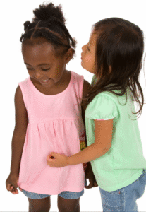 two preschool students are smiling and showing thankfulness by hugging
