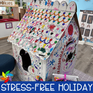 Colorful cardboard gingerbread house decorated by preschoolers during a holiday classroom activity.