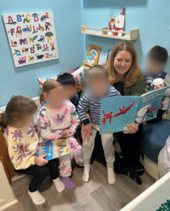 Winter preschool circle time setup with snow themed picture books and a cozy reading area.
