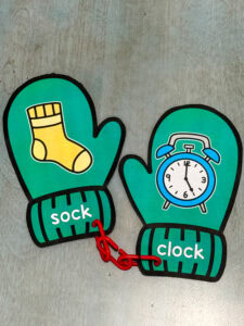 Winter rhyming mitten cards showing sock and clock connected with a plastic link for a preschool rhyming activity.